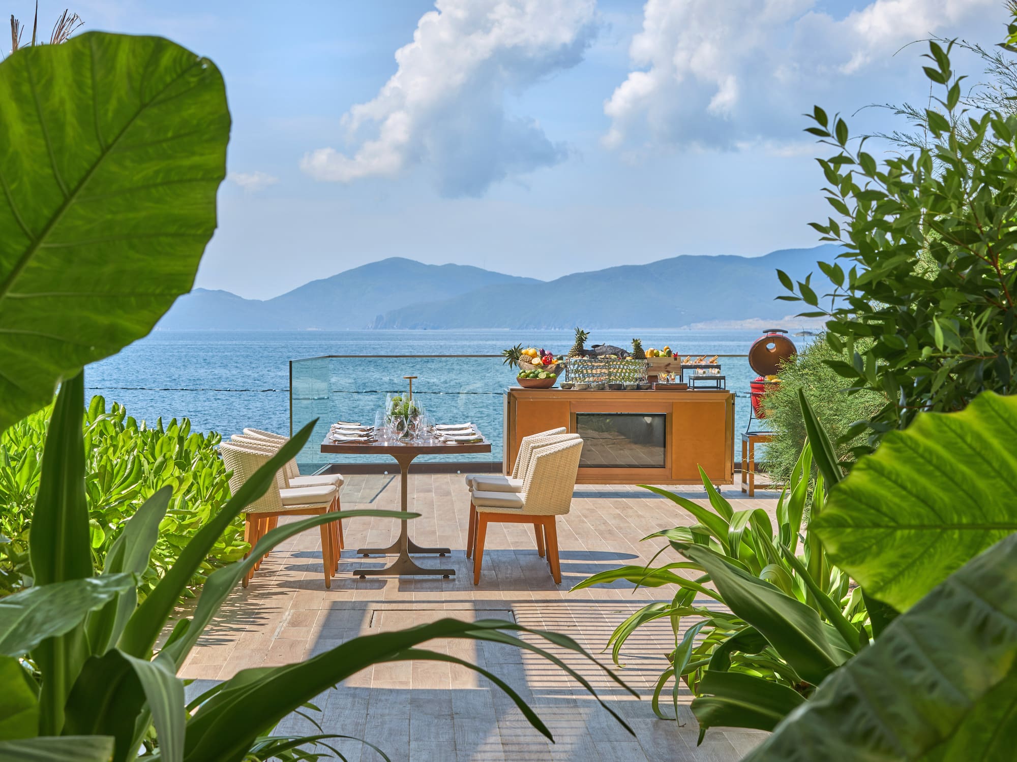 a table and chairs on a patio overlooking a body of water