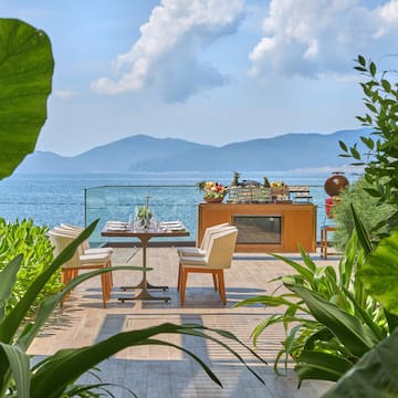 a table and chairs on a patio overlooking a body of water