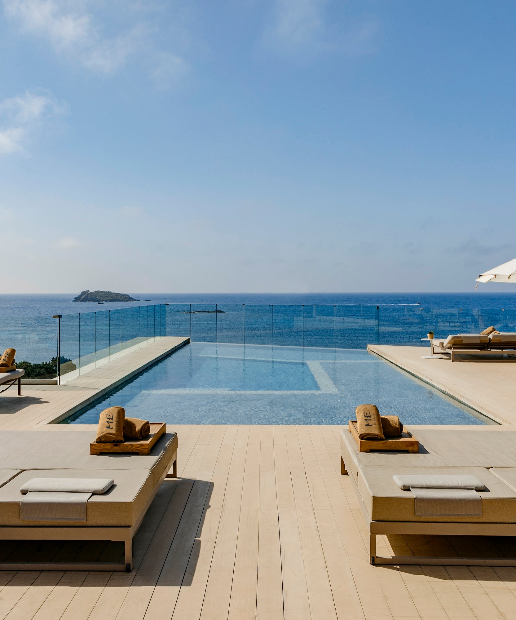 a pool with lounge chairs and umbrellas on a deck