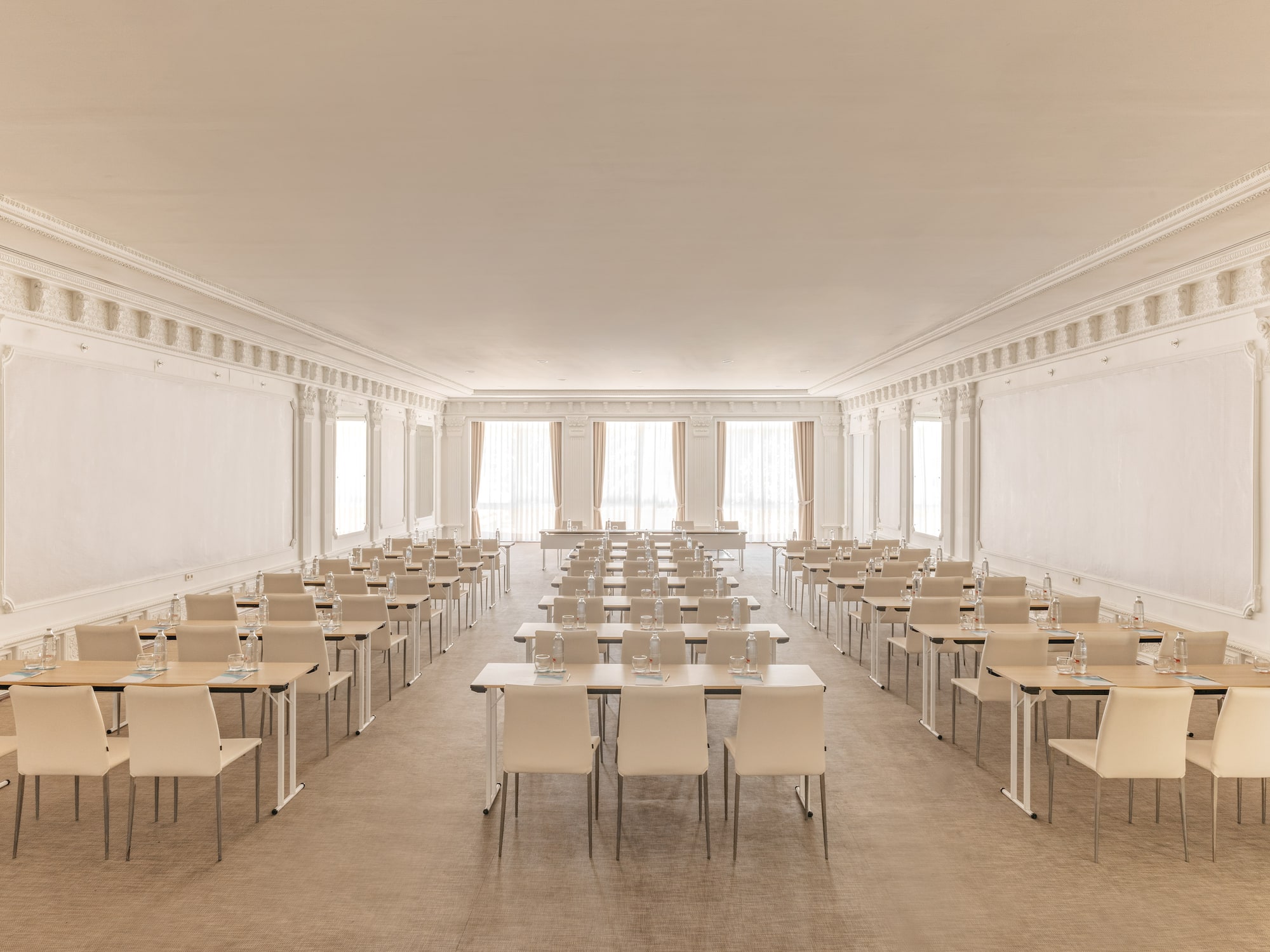 Elegant conference room with classroom setup, neutral tables and chairs.
