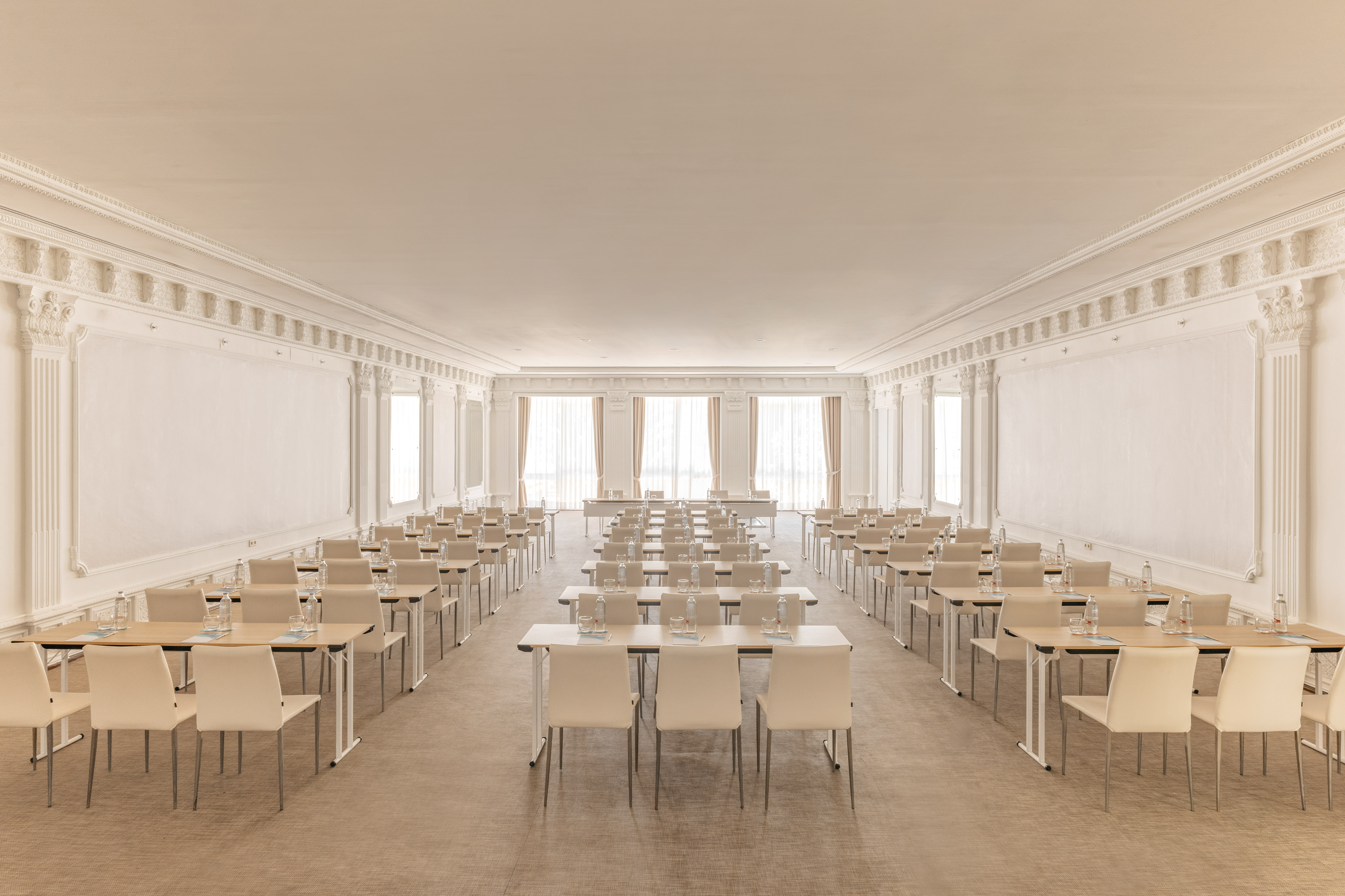 Elegant conference room with classroom setup, neutral tables and chairs.