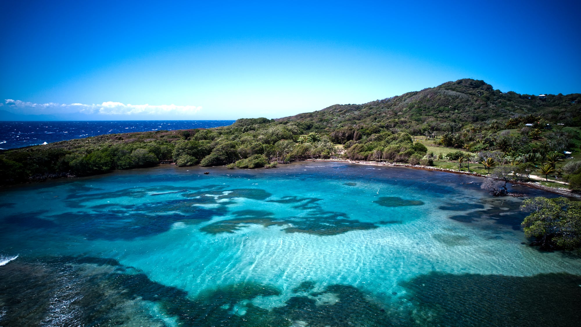 a body of water with trees and a hill in the background