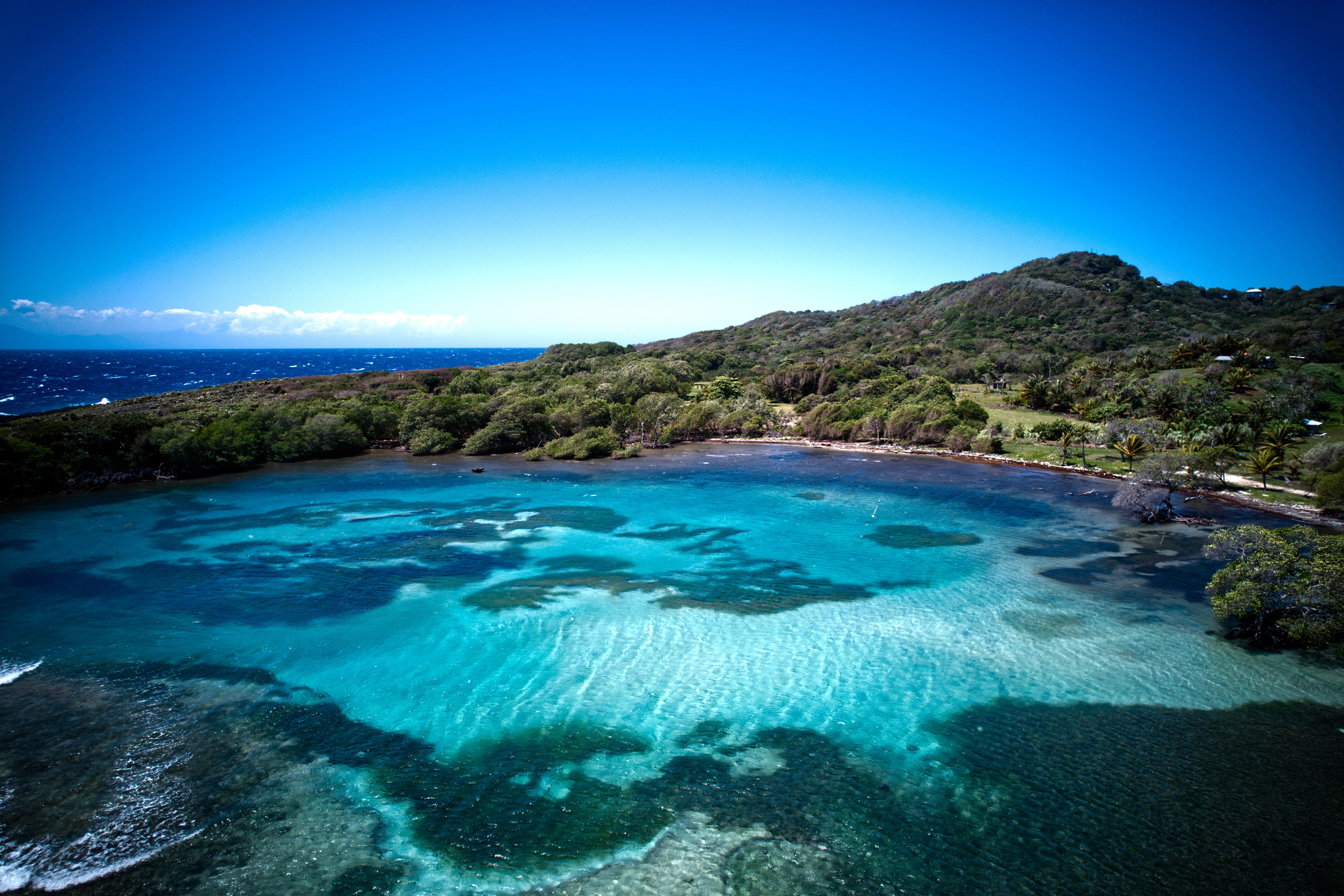 a body of water with trees and a hill in the background