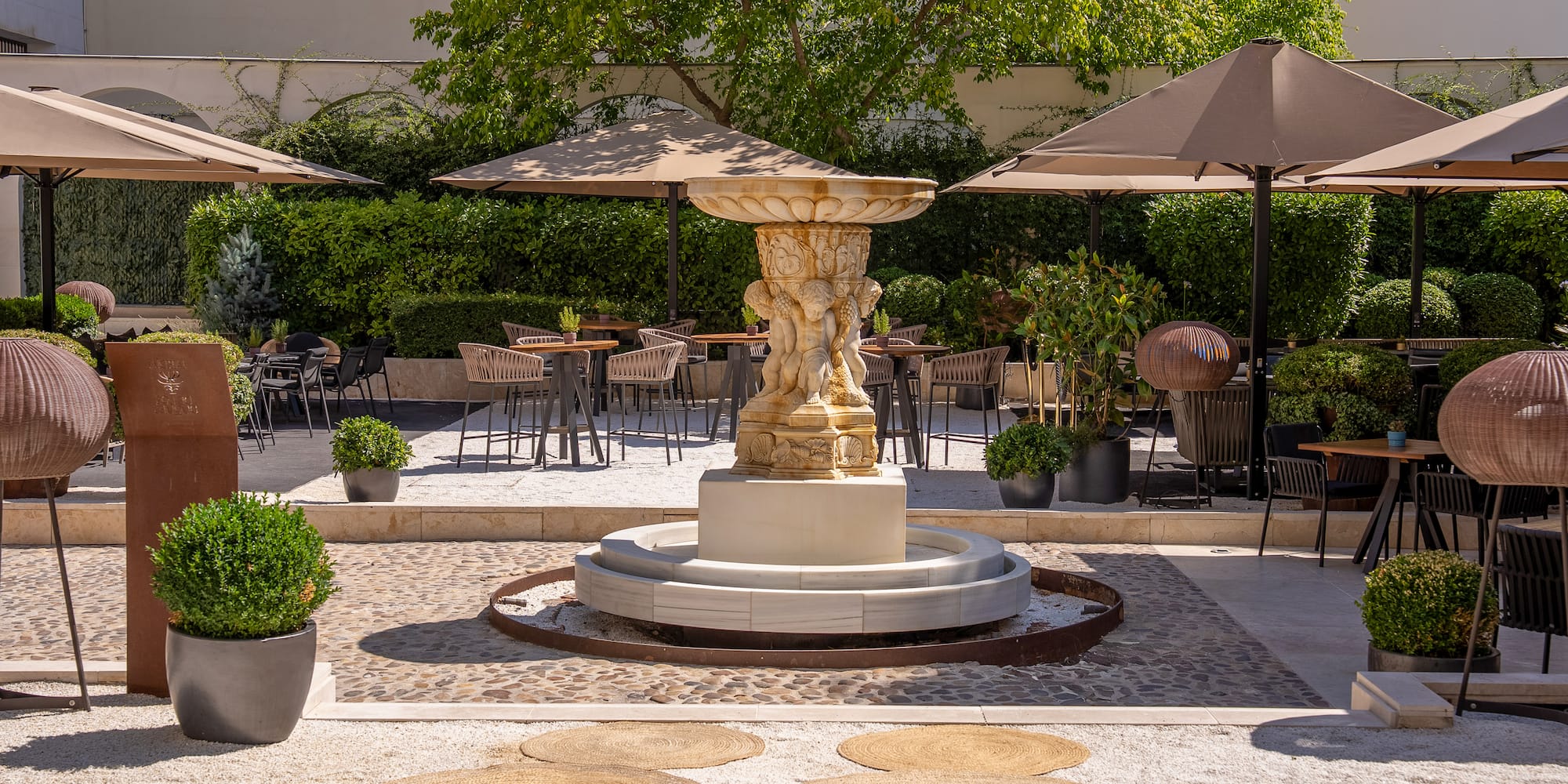 a fountain with a group of chairs and umbrellas