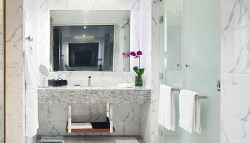 a bathroom with a marble countertop sink and a glass shower door