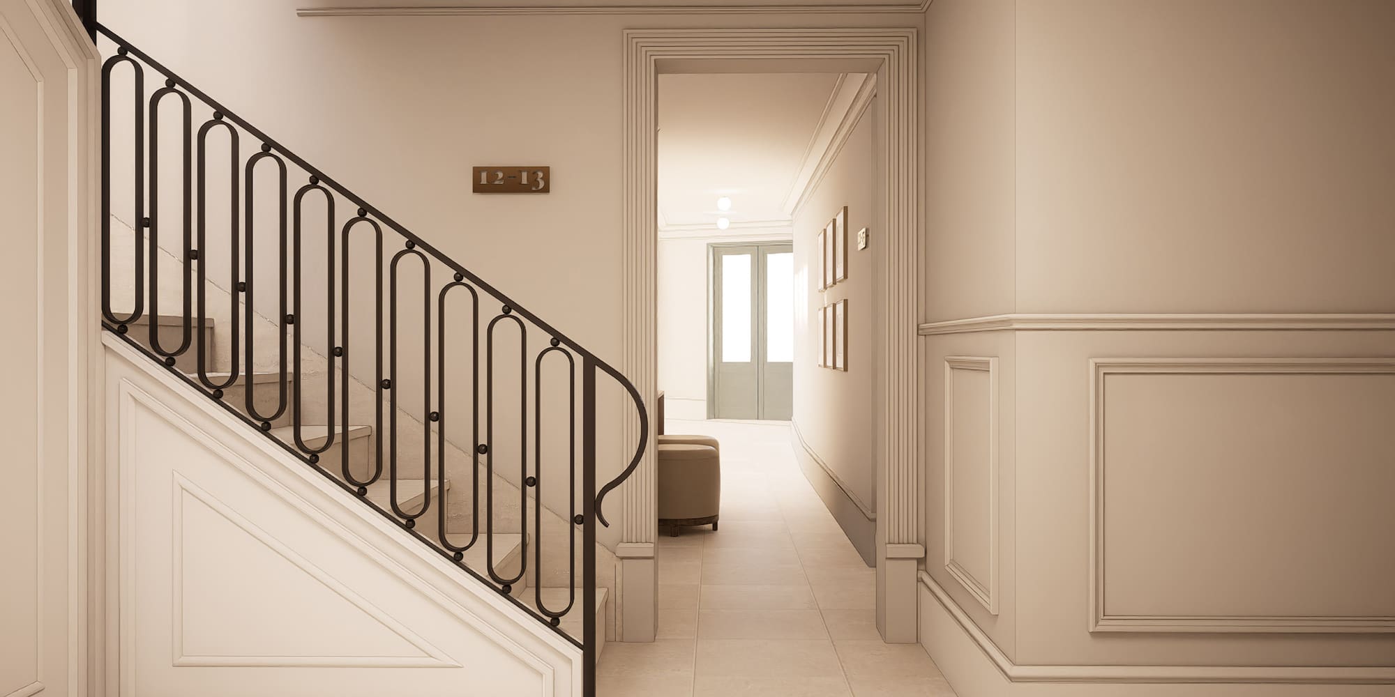 Elegant residential hallway with staircase, black wrought iron railing, and cream walls.