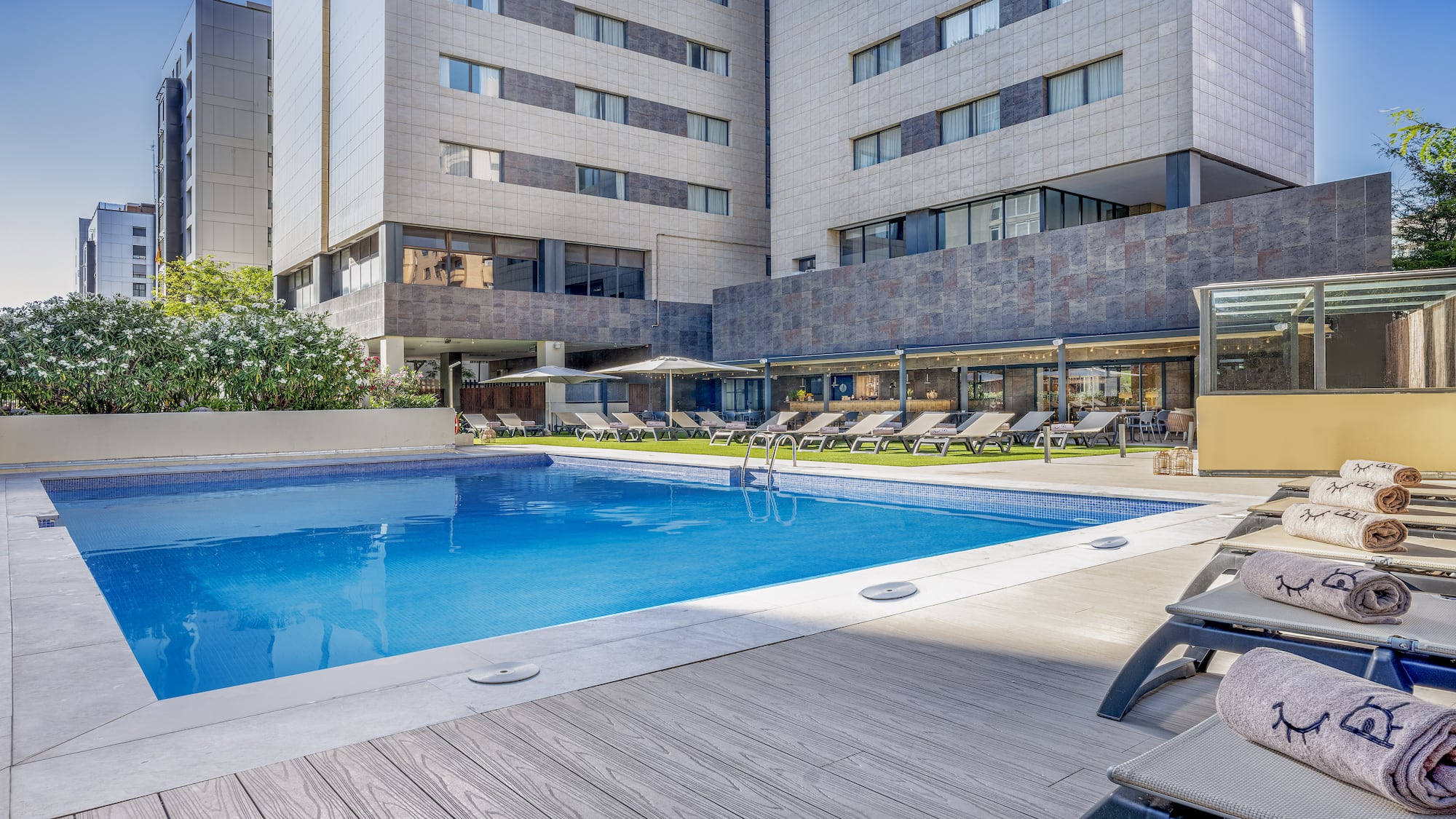 a pool with lounge chairs and a building in the background