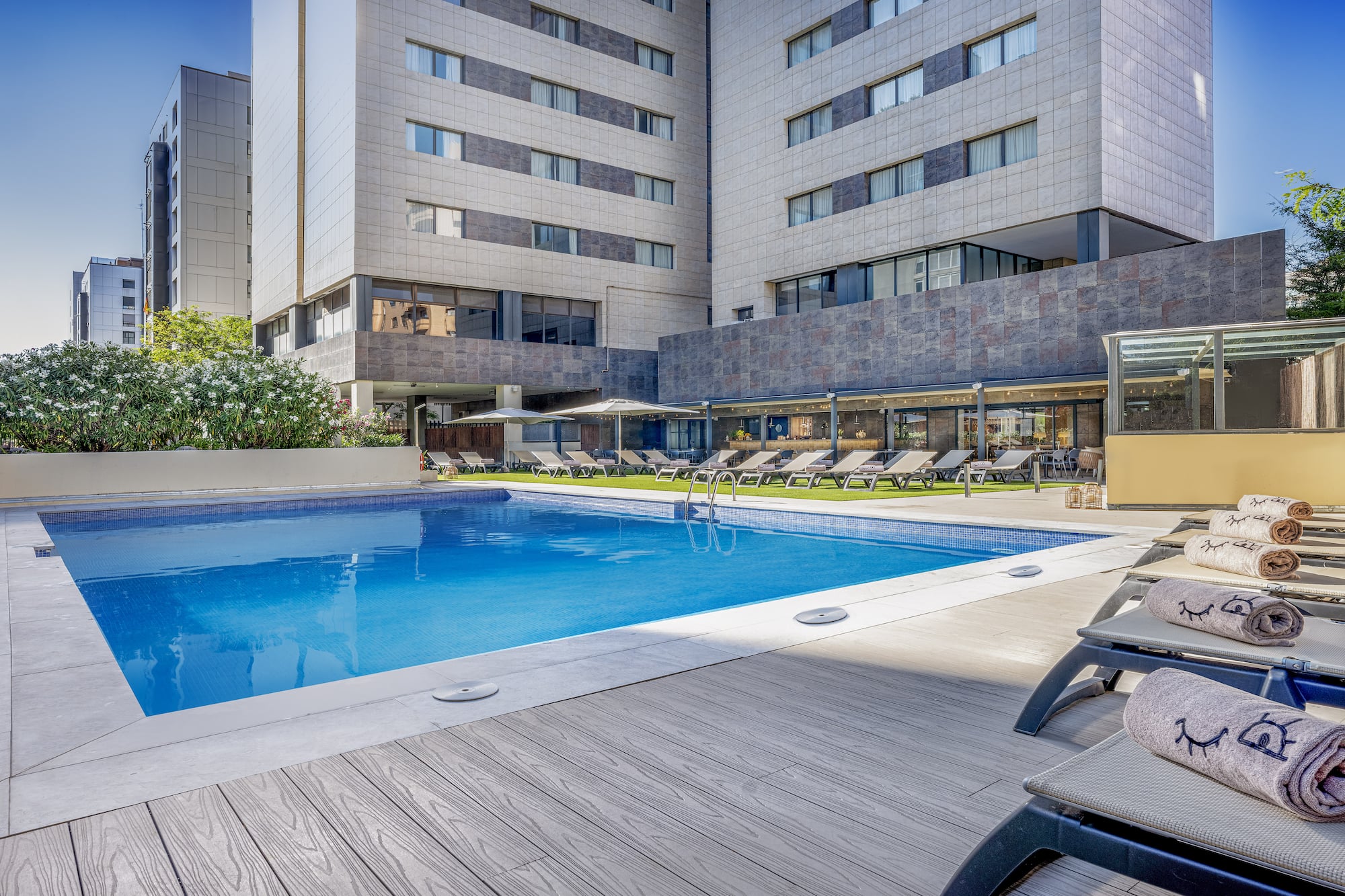 a pool with lounge chairs and a building in the background