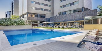 a pool with lounge chairs and a building in the background