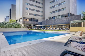 a pool with lounge chairs and a building in the background