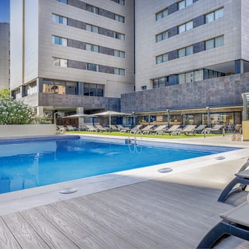 a pool with lounge chairs and a building in the background