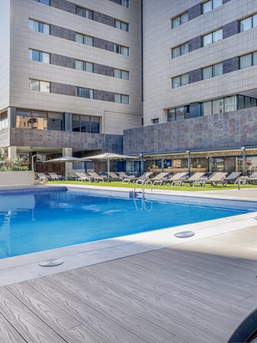 a pool with lounge chairs and a building in the background