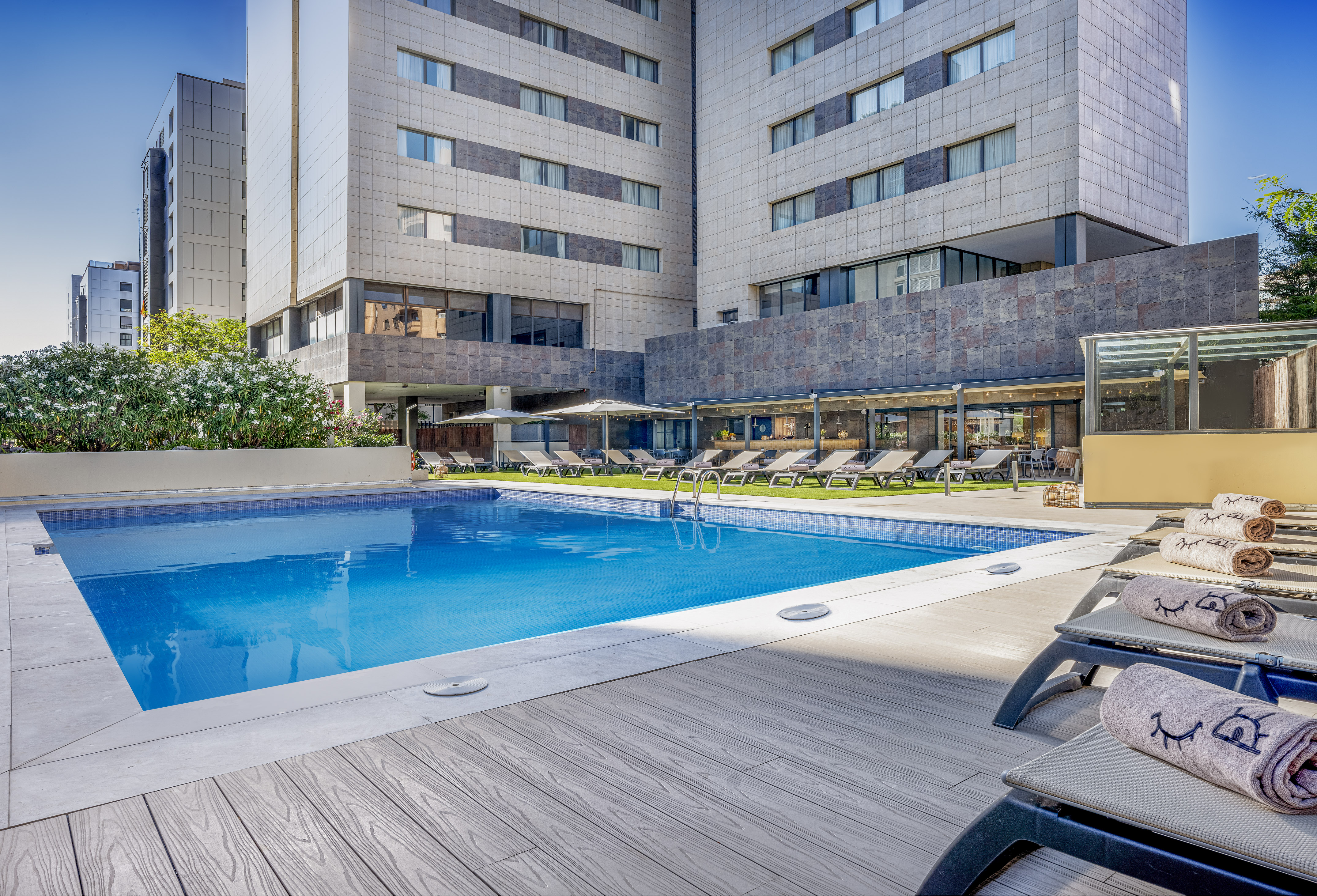 a pool with lounge chairs and a building in the background