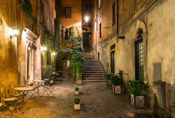 a courtyard with stairs and tables and plants