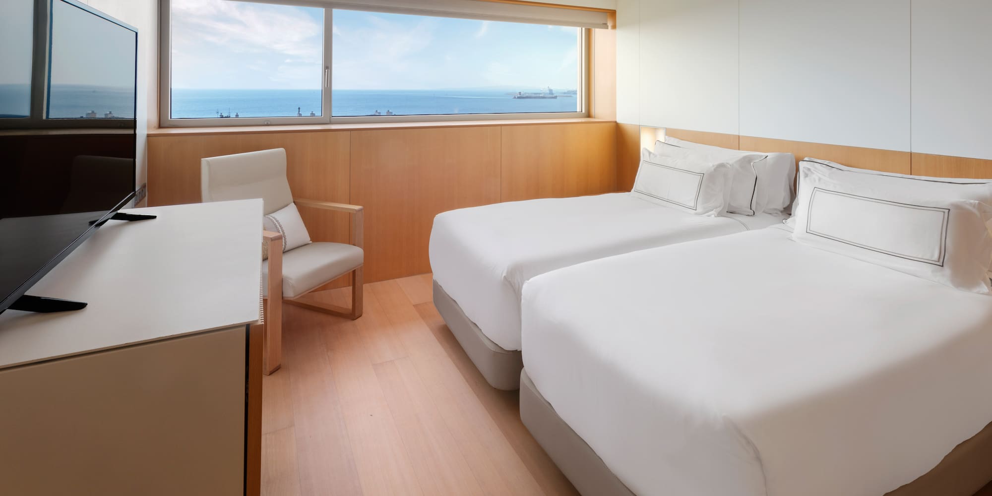 a room with two beds and a chair