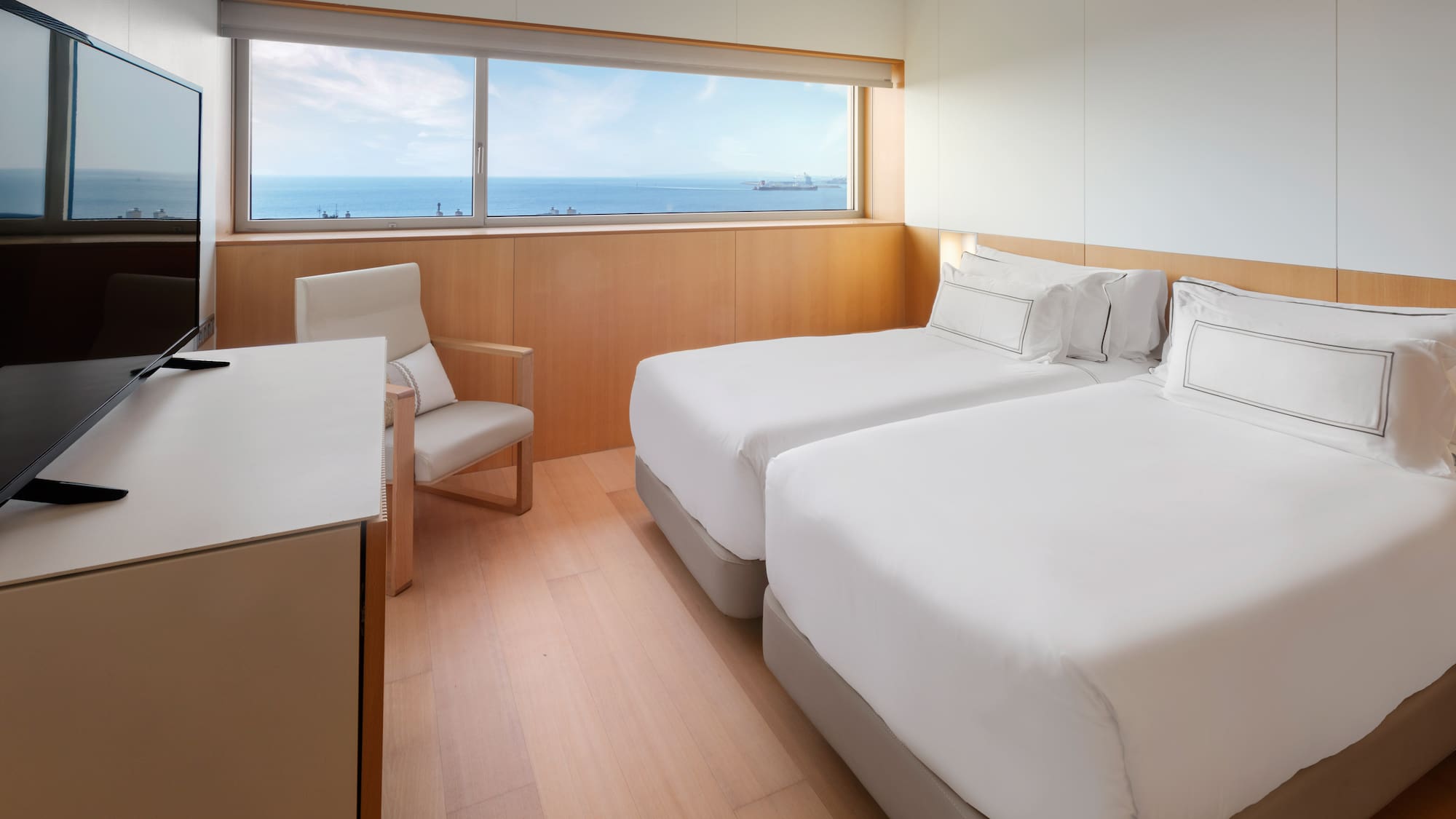 a room with two beds and a chair