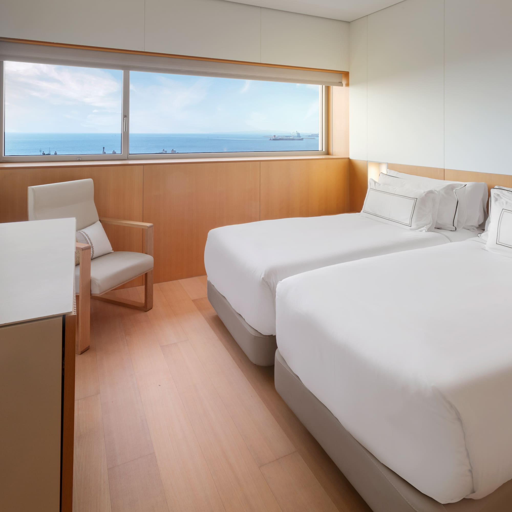 a room with two beds and a chair