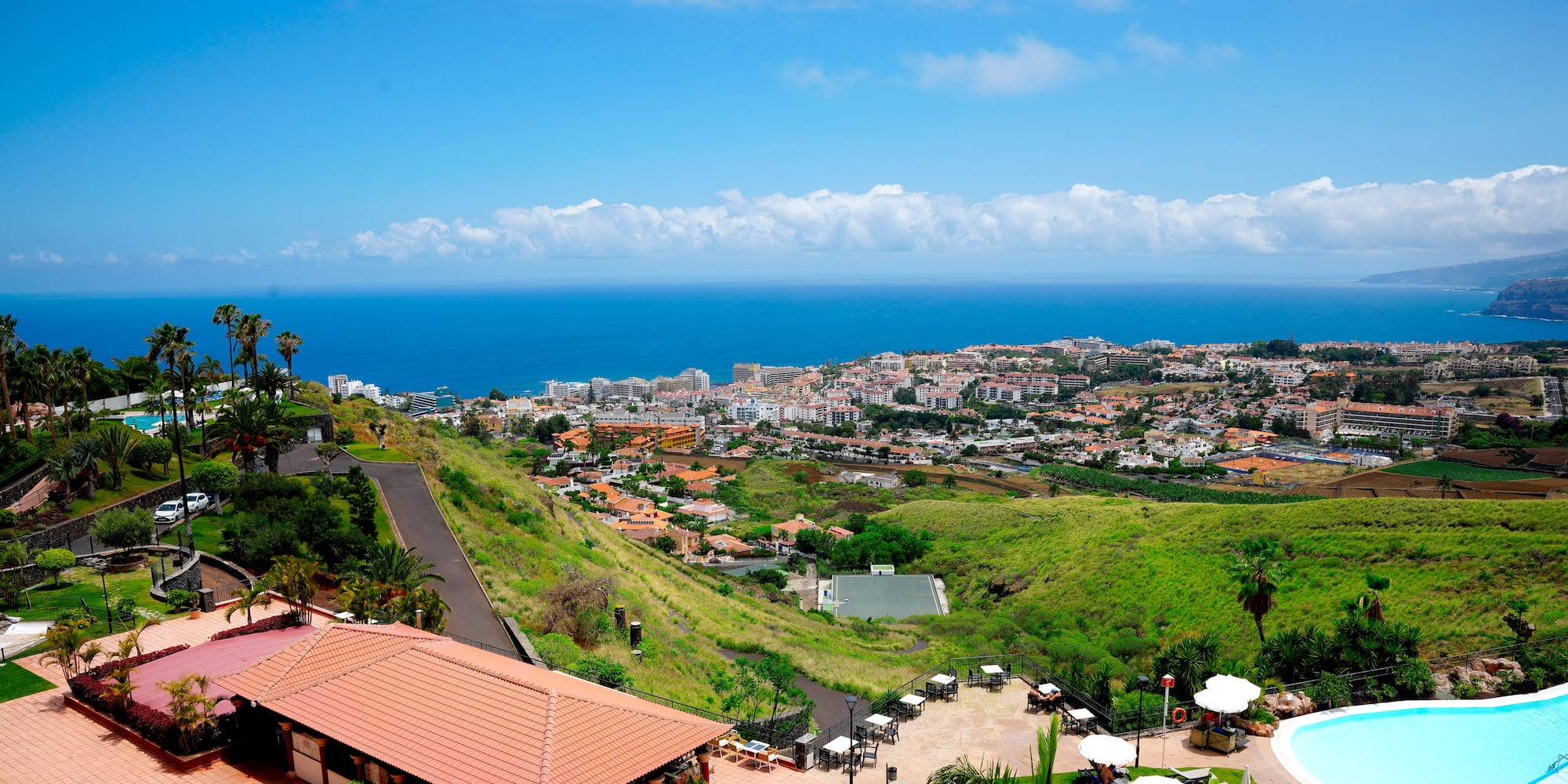a pool and buildings on a hill