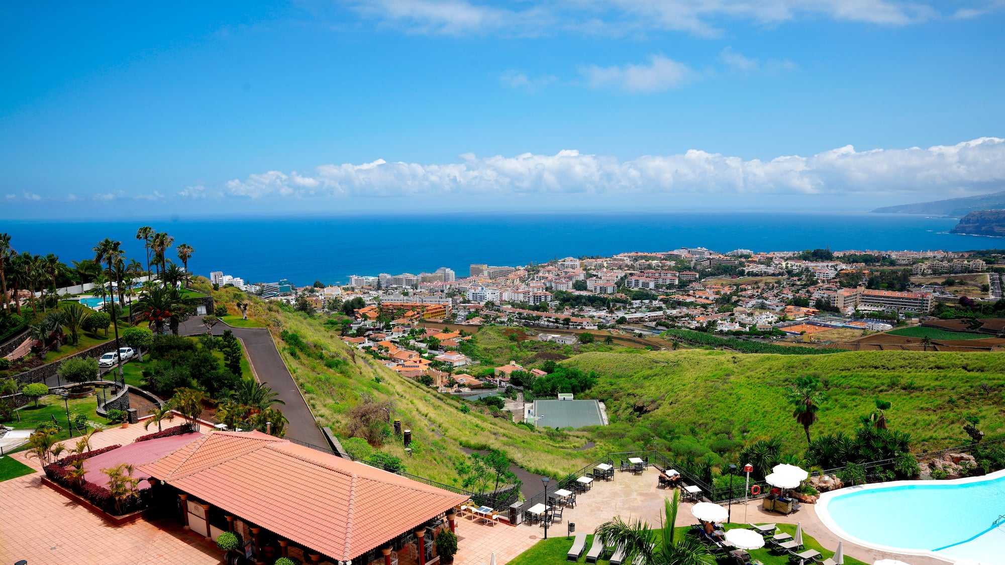 a pool and buildings on a hill