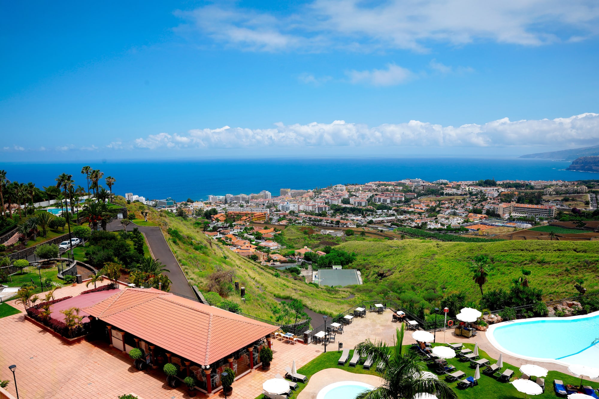 a pool and buildings on a hill