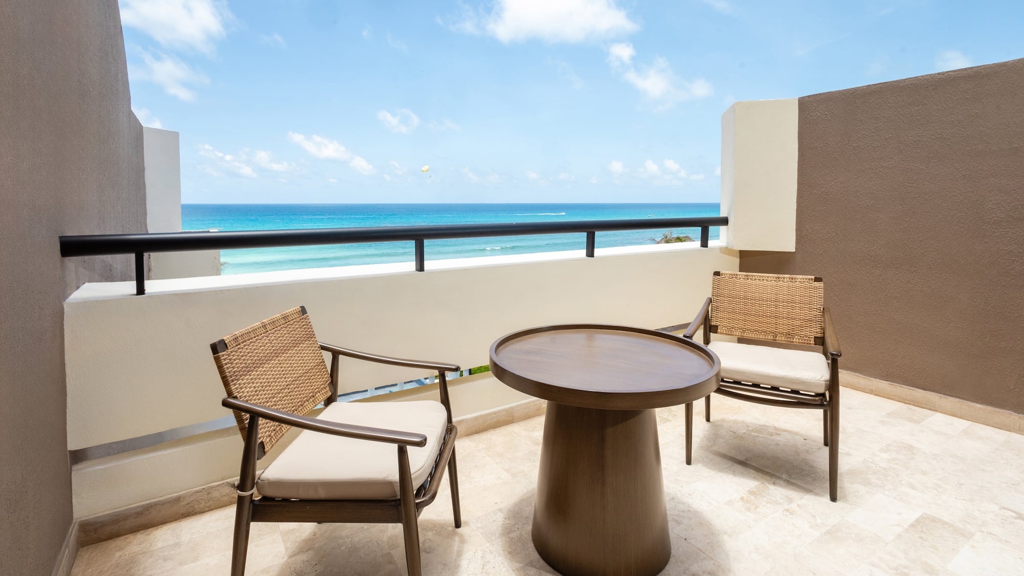 a table and chairs on a balcony overlooking the ocean