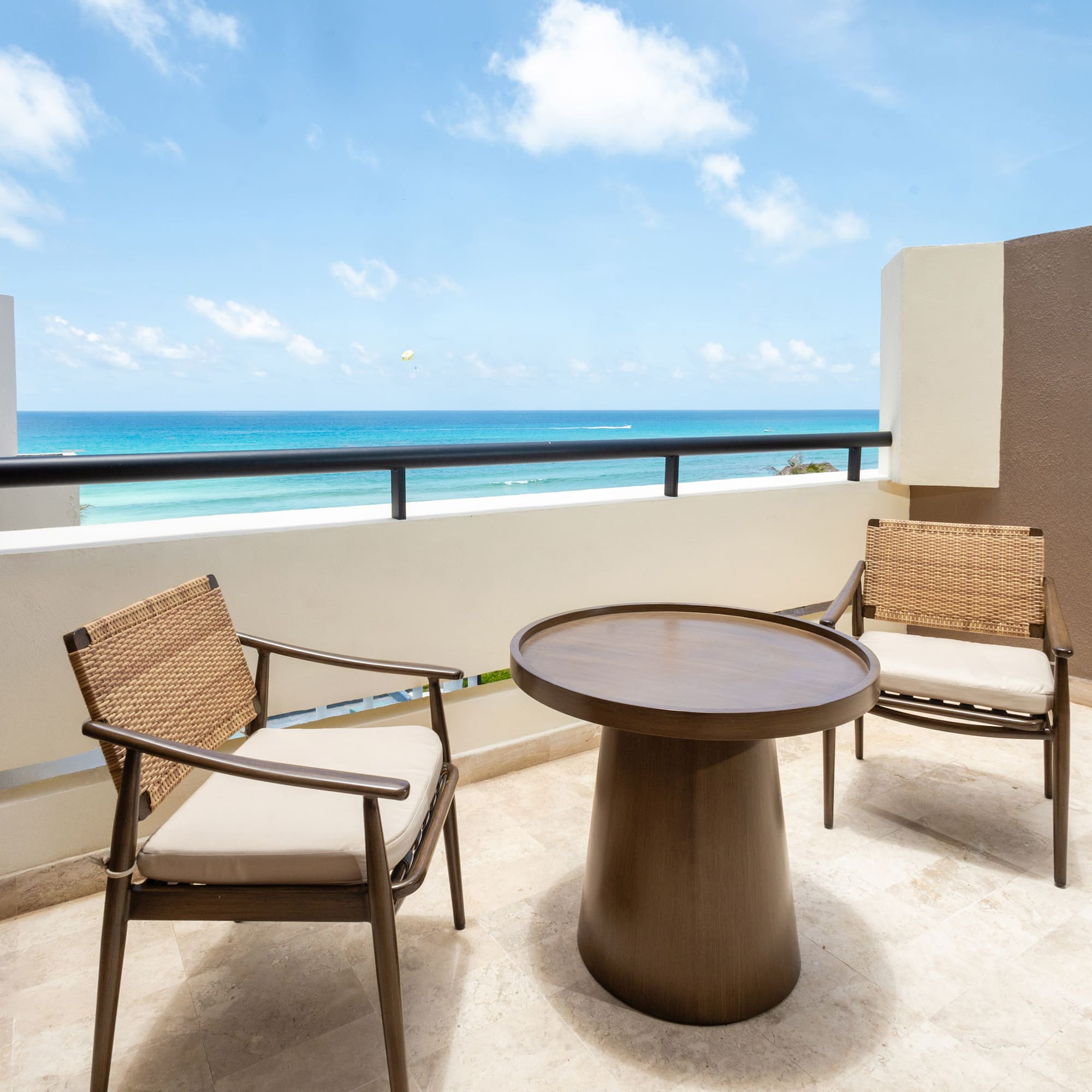a table and chairs on a balcony overlooking the ocean