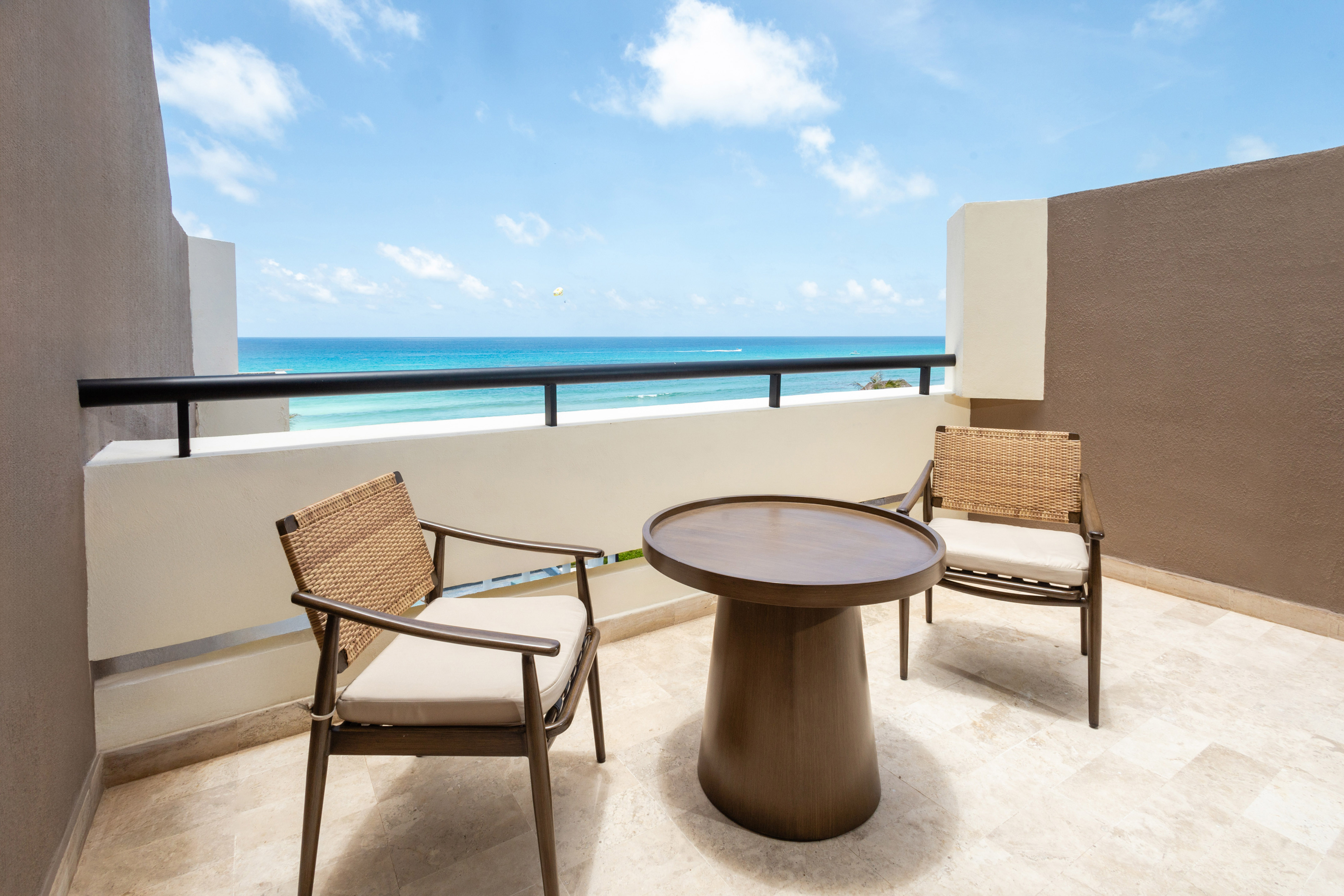 a table and chairs on a balcony overlooking the ocean