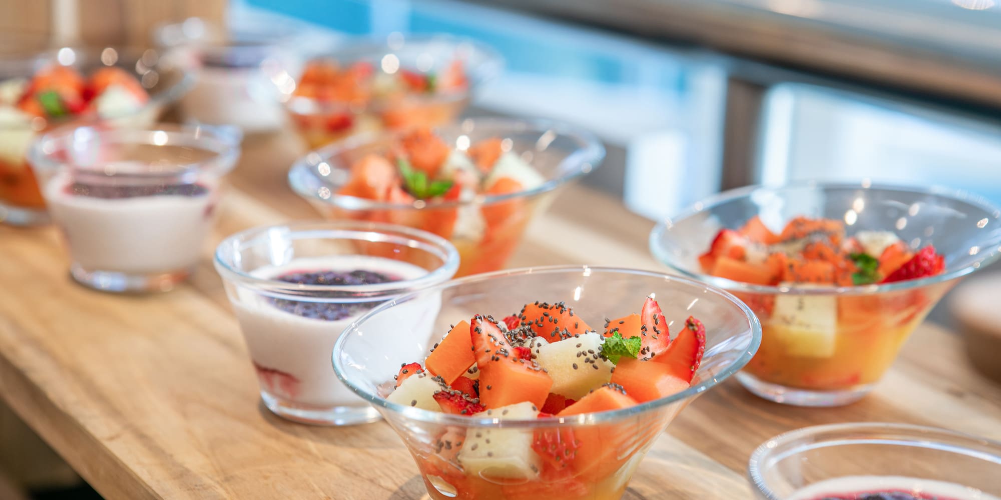 a table with bowls of fruit and yogurt