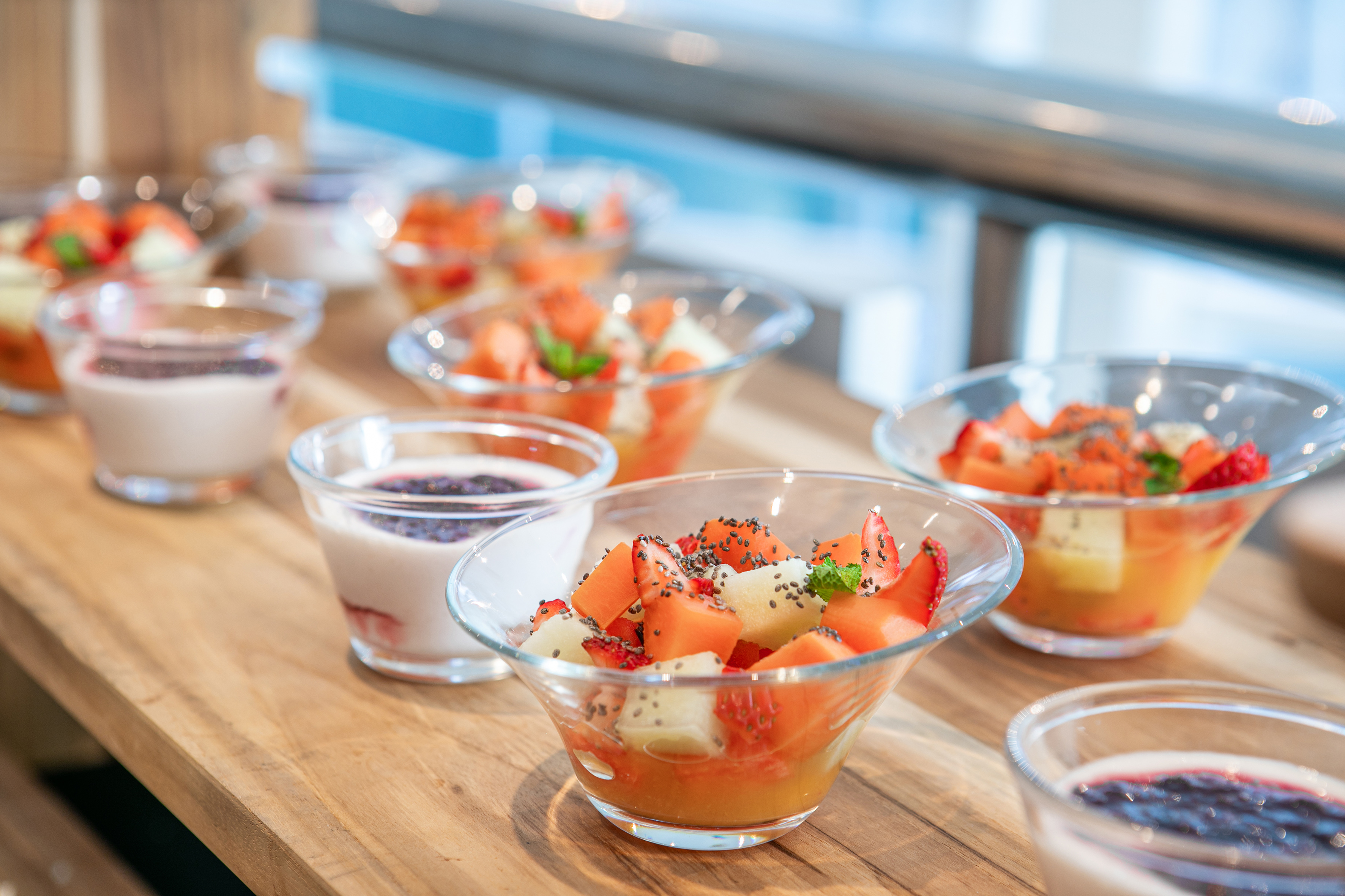 a table with bowls of fruit and yogurt