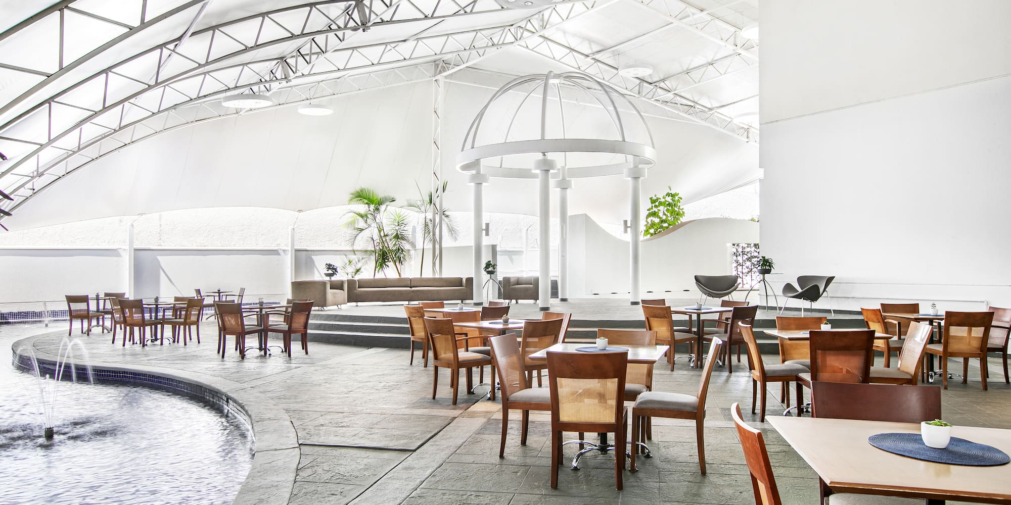 a room with tables and chairs and a pool