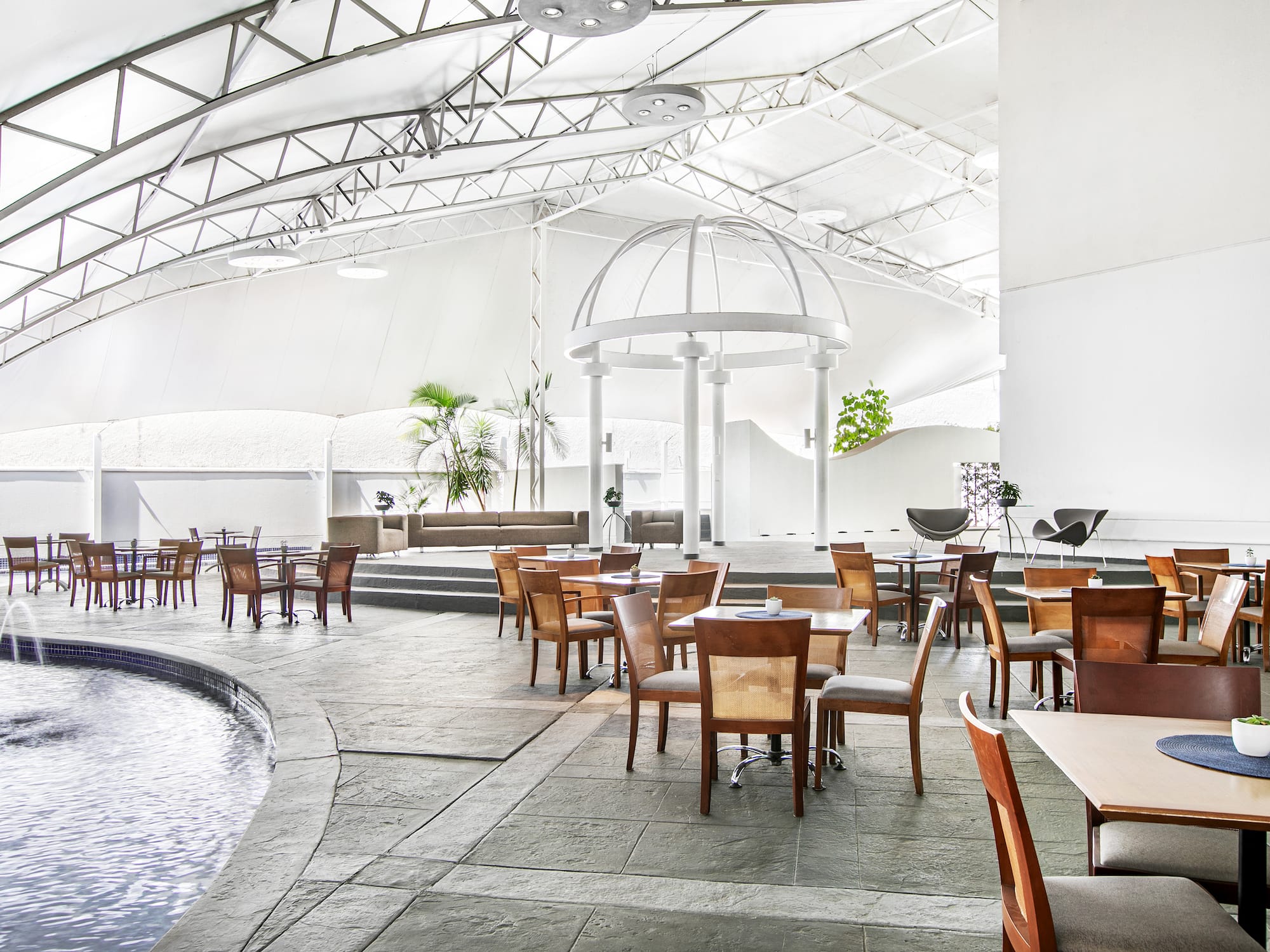 a room with tables and chairs and a pool