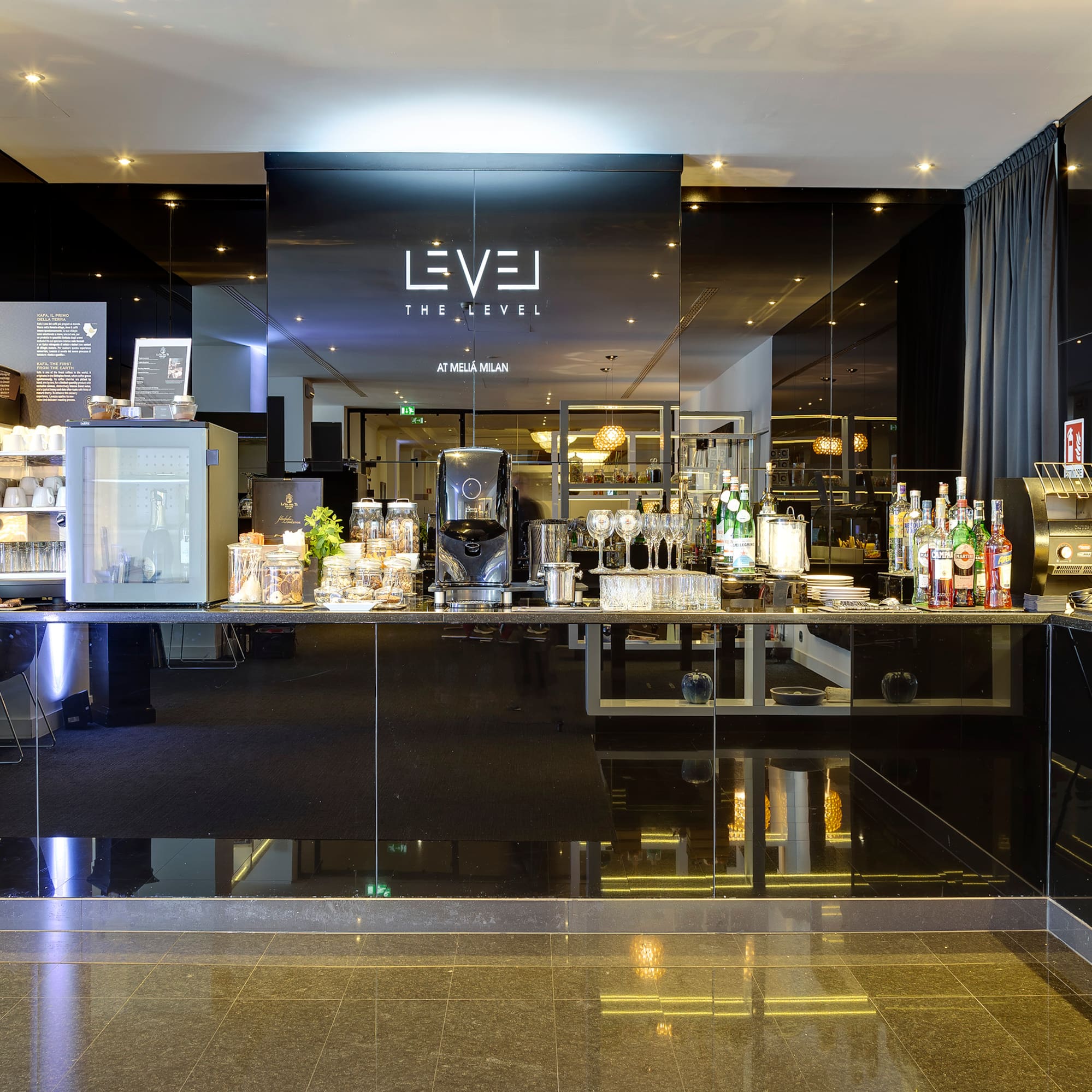Melia Milan The Level hotel lounge with coffee bar and breakfast buffet.