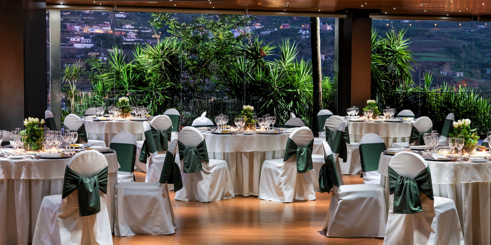 a room with tables and chairs with green bows