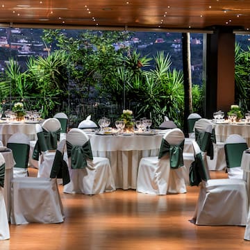 a room with tables and chairs with green bows