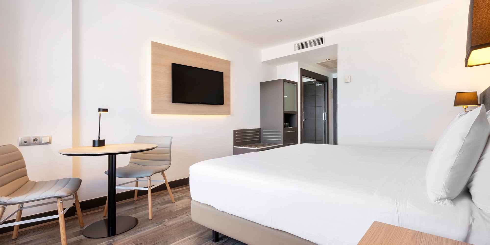 a room with a bed and a table and chairs