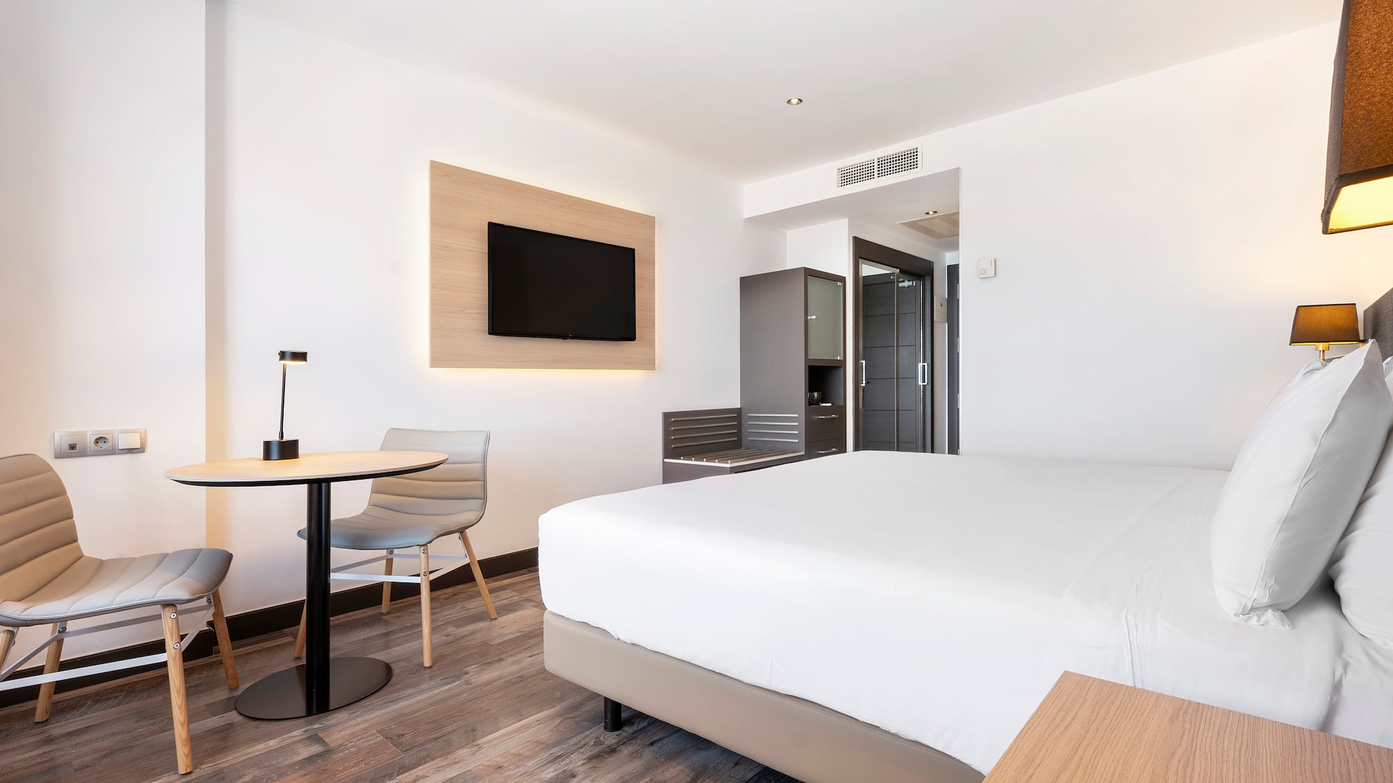 a room with a bed and a table and chairs