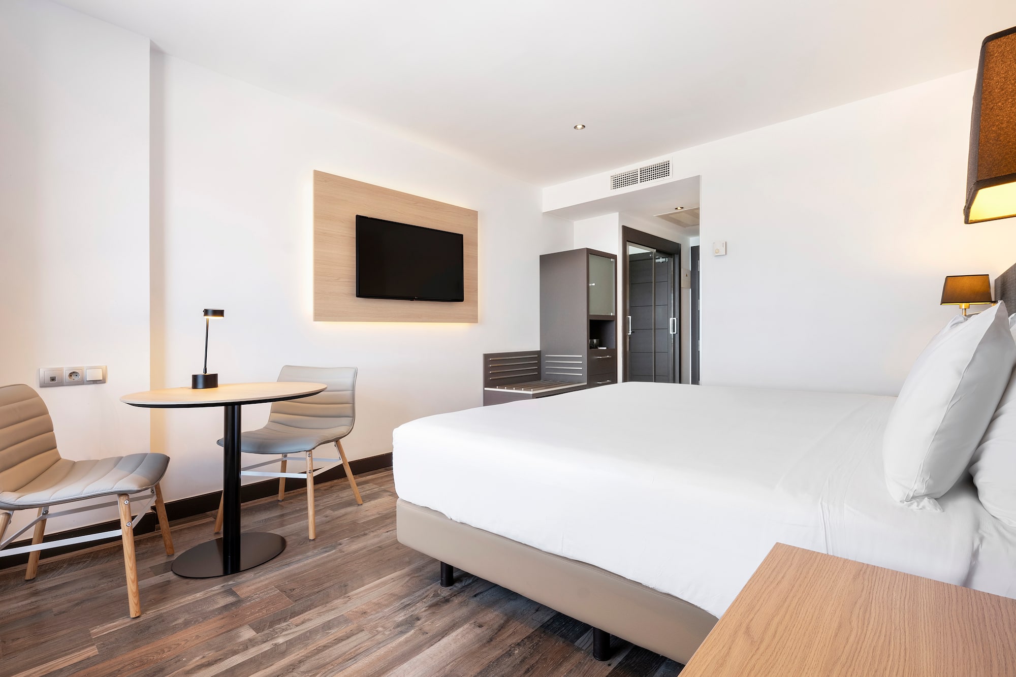 a room with a bed and a table and chairs