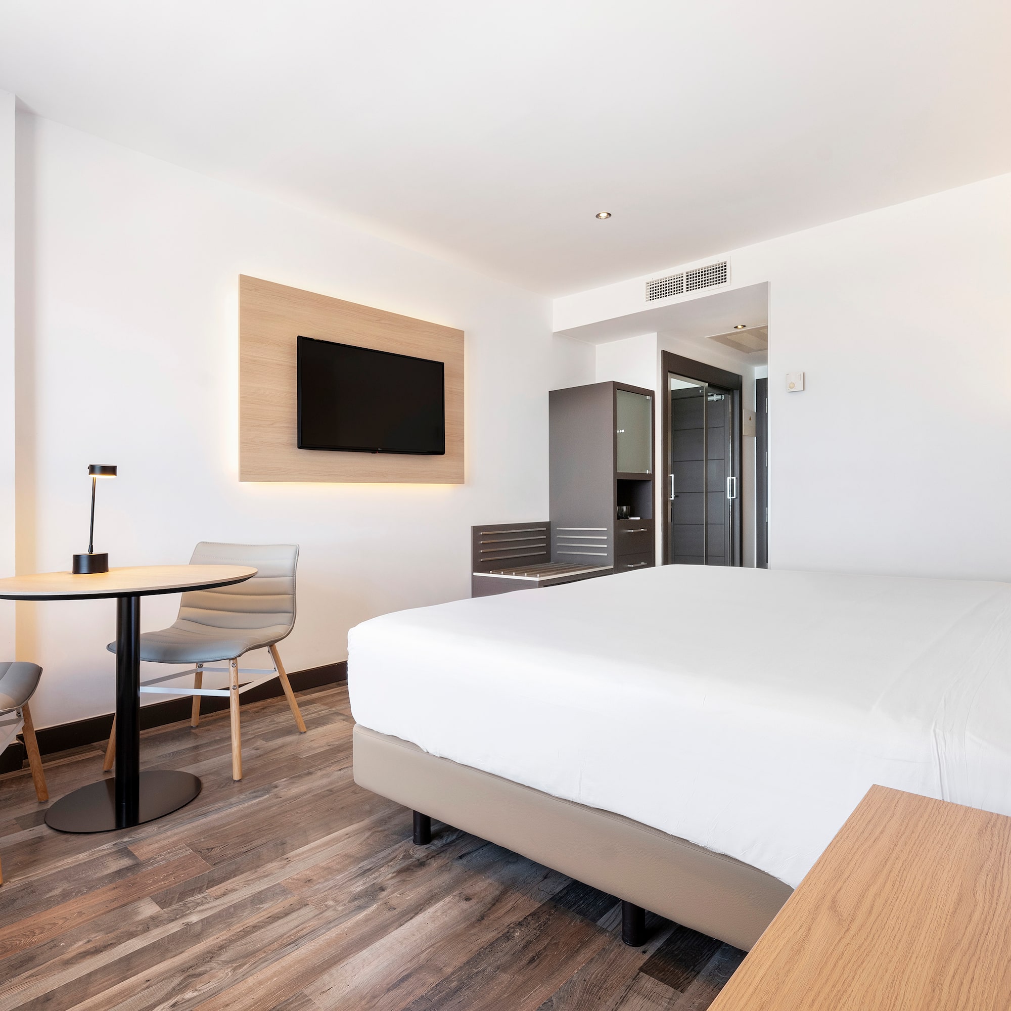 a room with a bed and a table and chairs