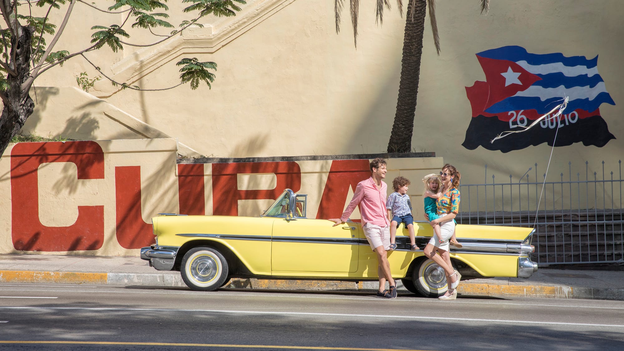 a family standing on a convertible car