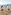Family with two kids walking on a sandy beach by the ocean.