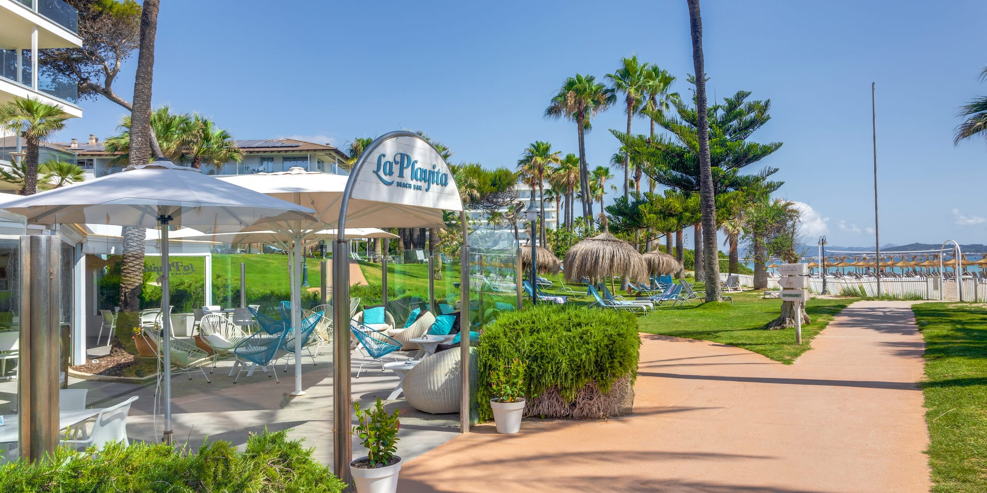 a walkway with umbrellas and chairs on it