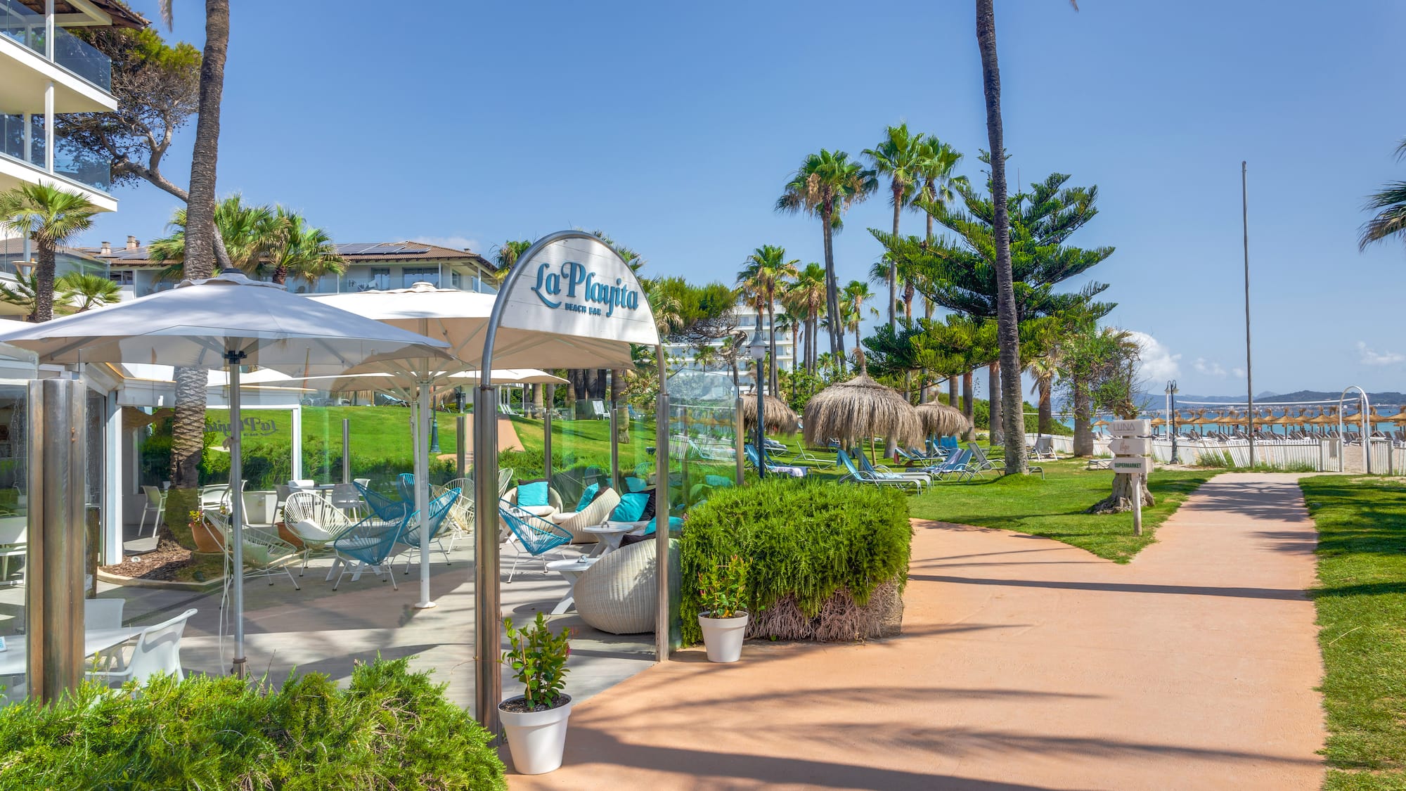 a walkway with umbrellas and chairs on it