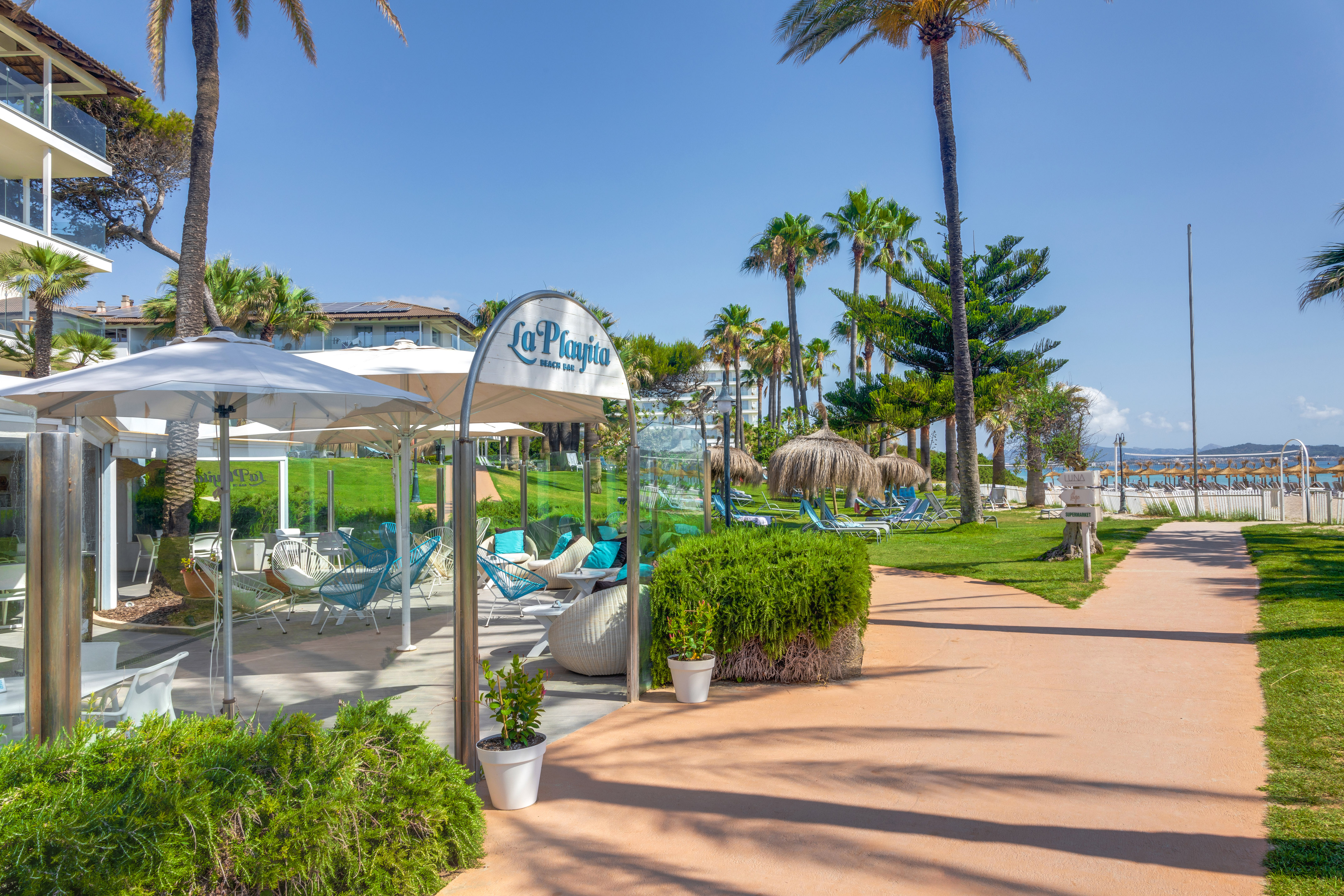 a walkway with umbrellas and chairs on it