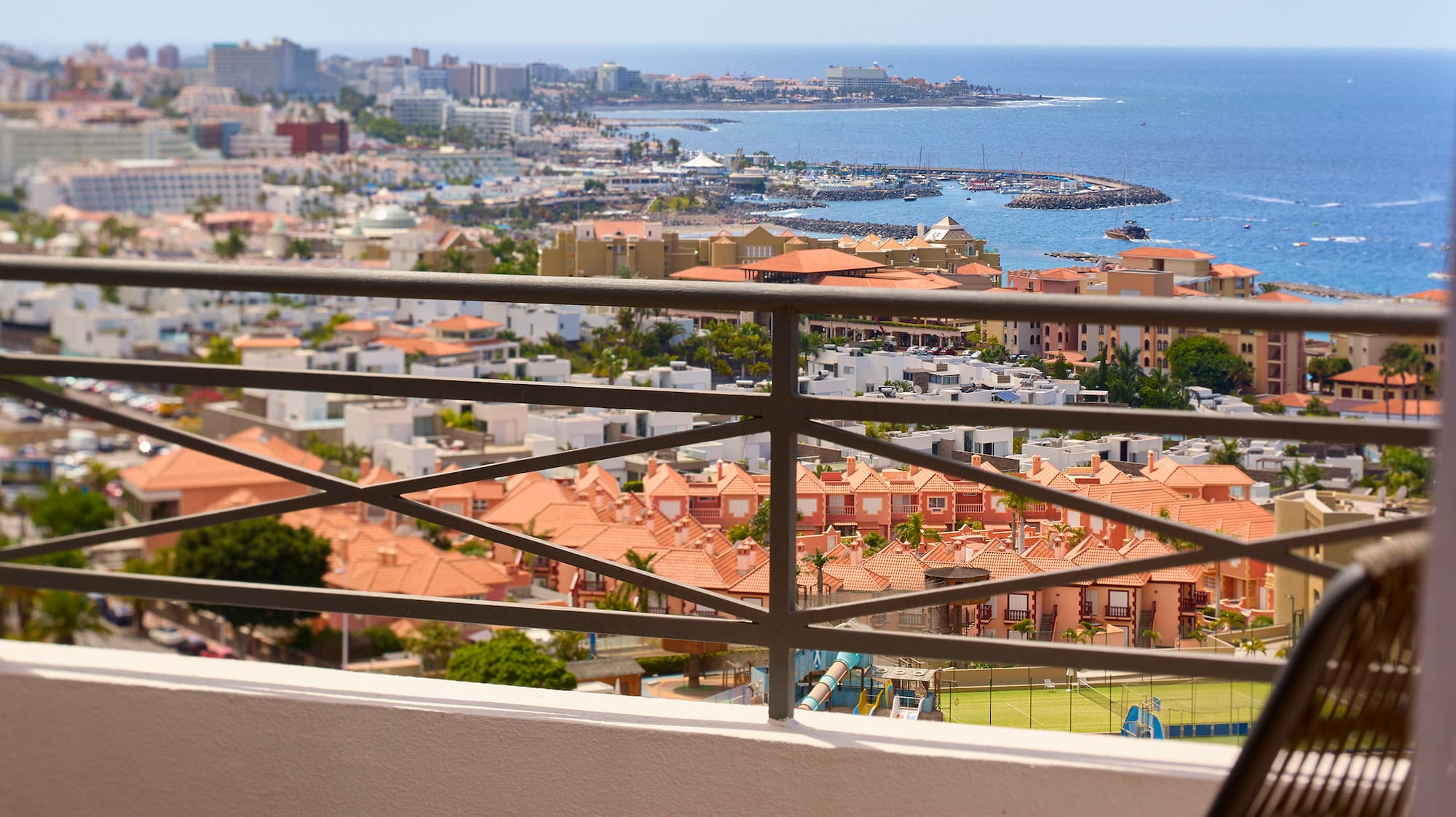 a chair and table with a view of a city and water