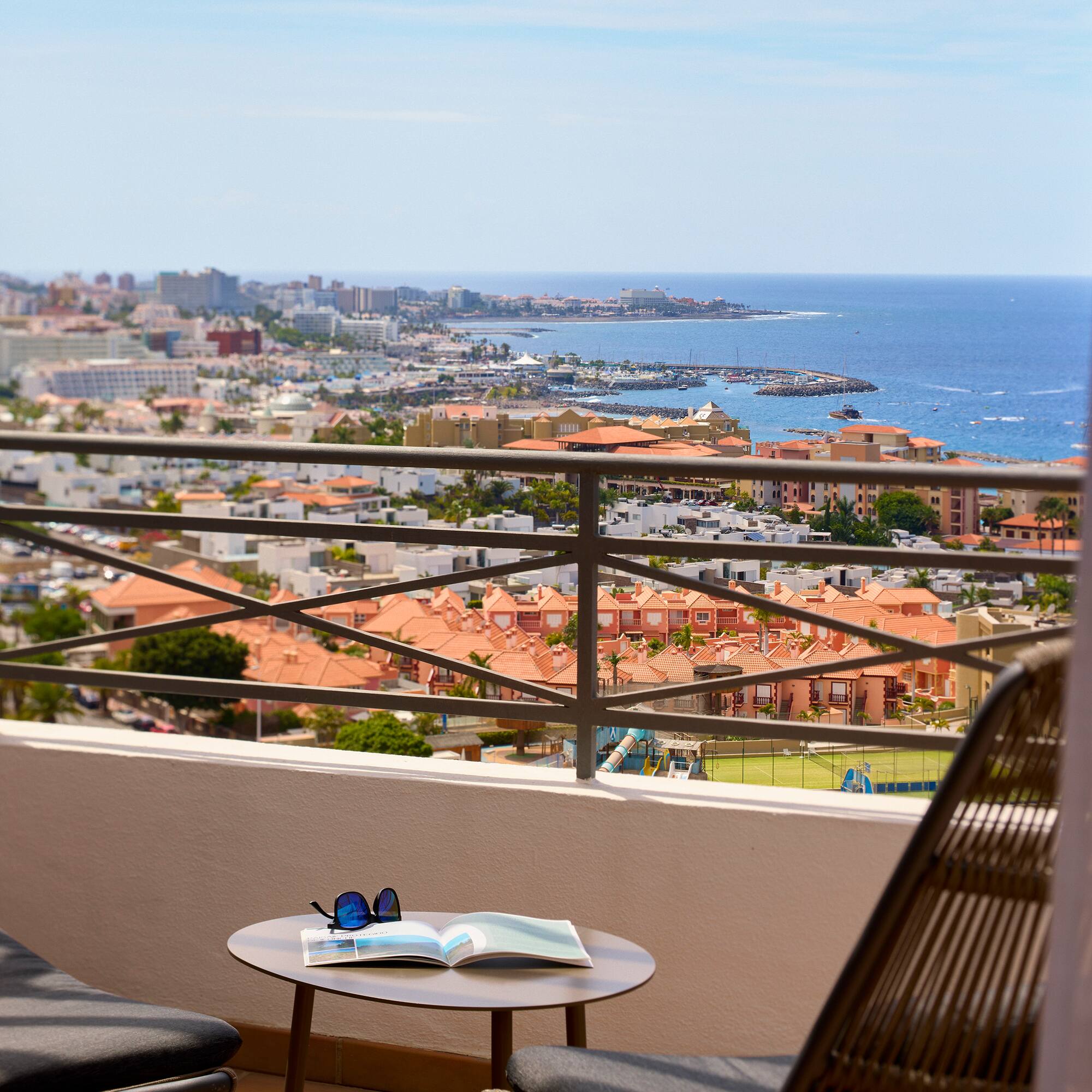 a chair and table with a view of a city and water