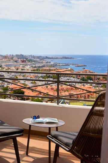 a chair and table with a view of a city and water