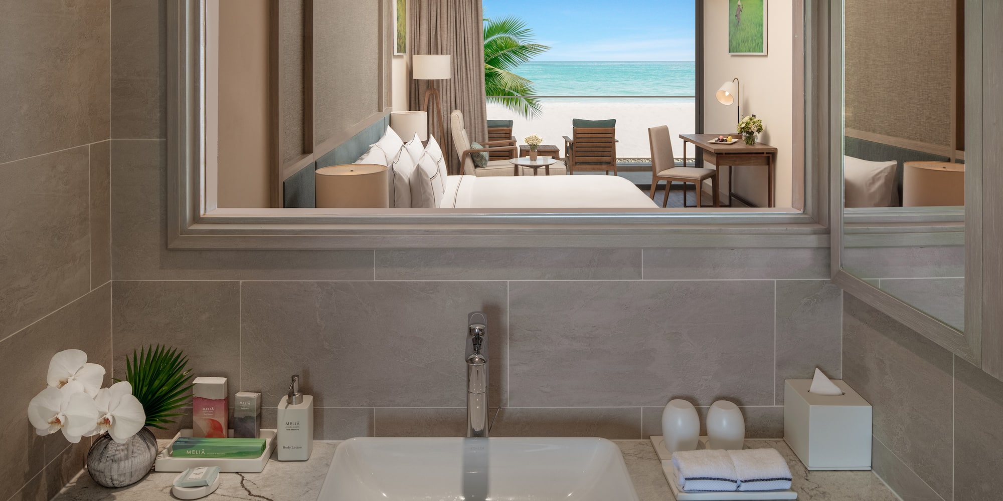 a bathroom with a mirror and a view of the ocean