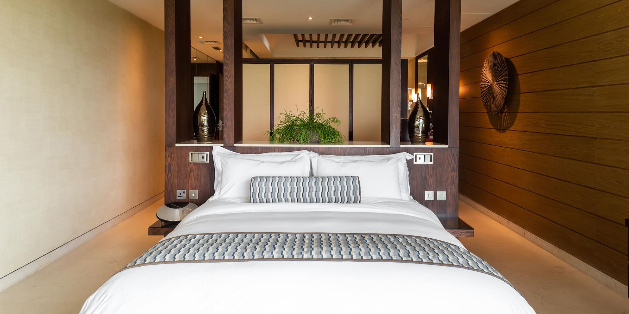 a bed with white pillows and a wood wall