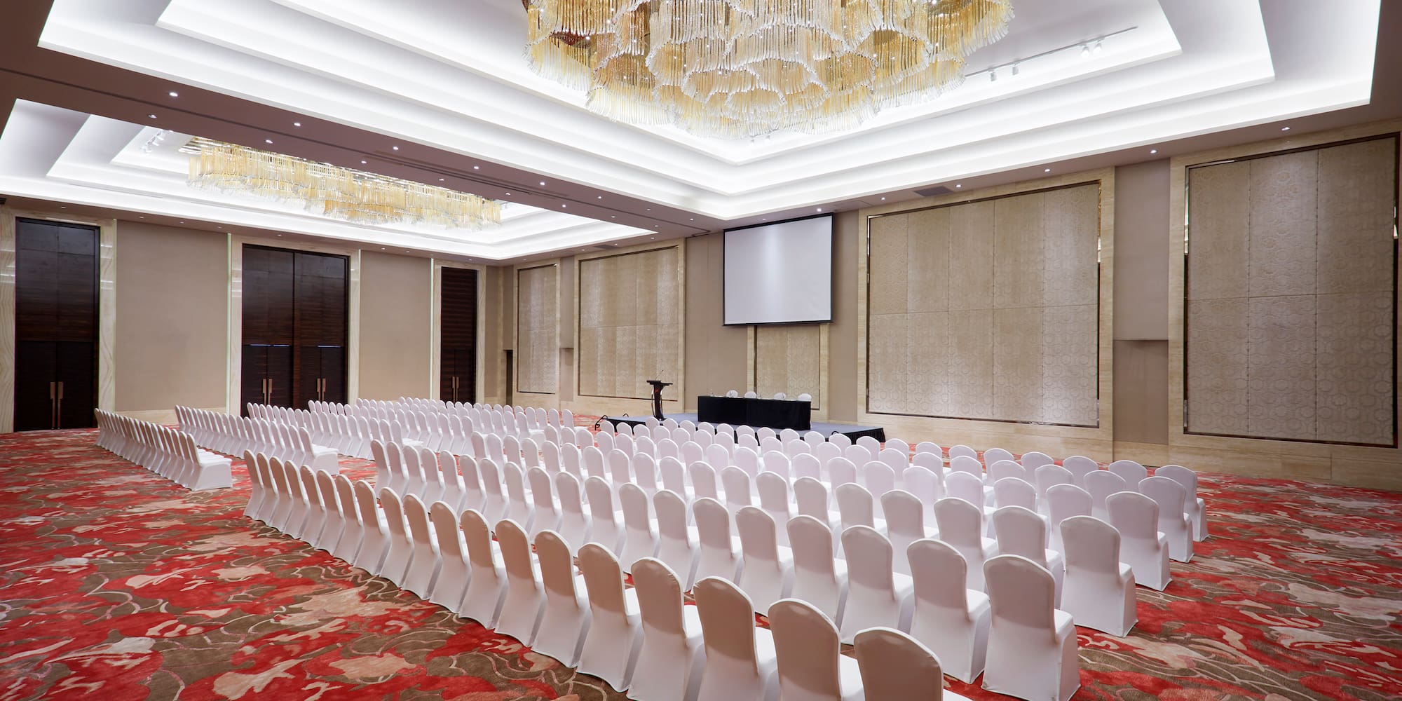 a room with chairs and chandeliers