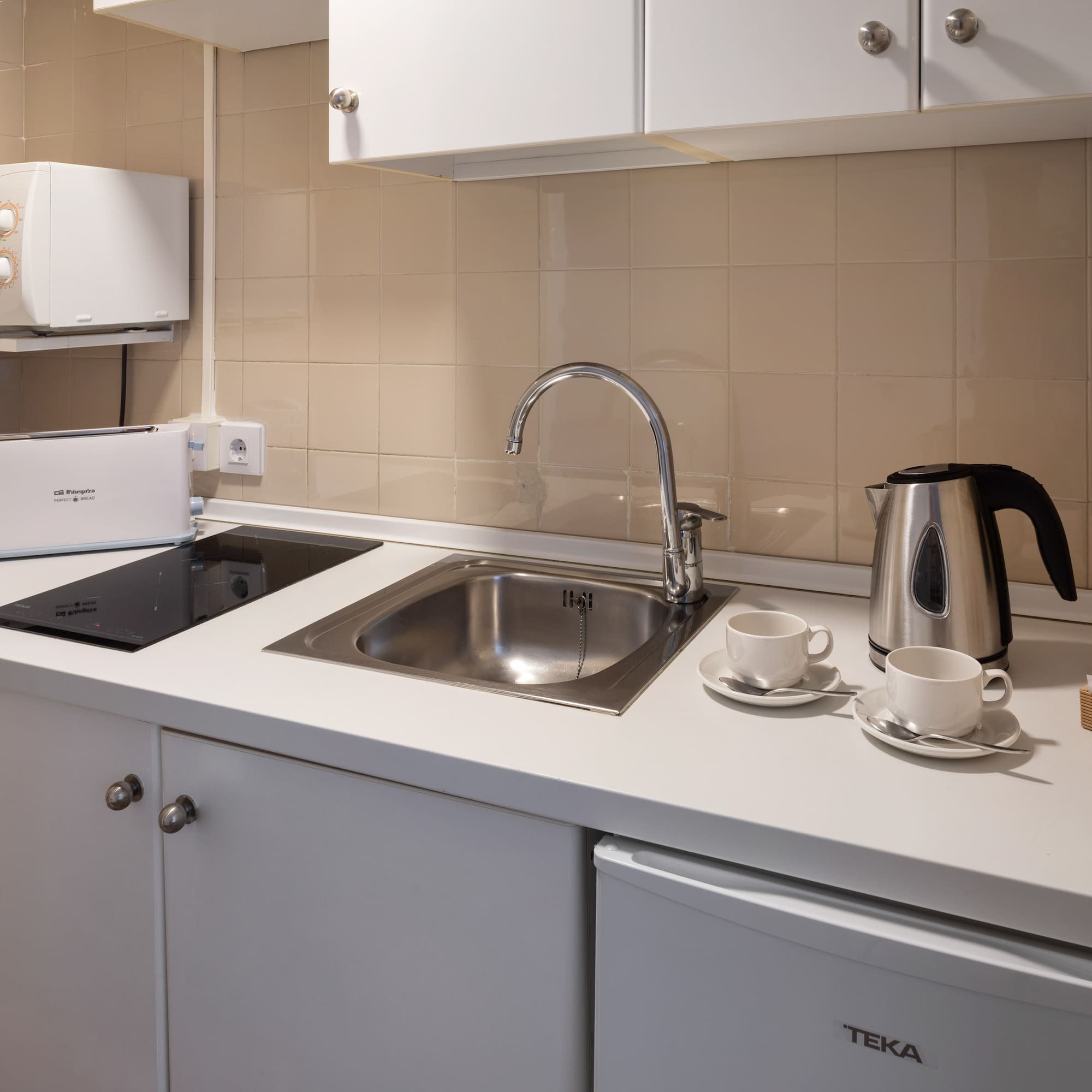 a kitchen with a sink and a kettle